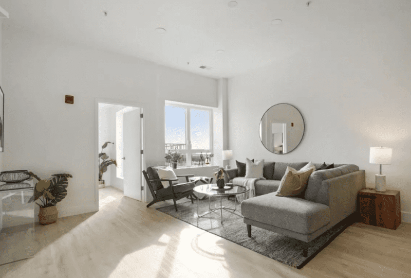 Hermoso salón luminoso con vistas al exterior y decoración moderna, ideal para residencias en alquiler en Horus Real Estate Agency.