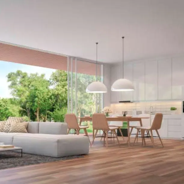 Luminoso salón comedor y cocina moderna en vivienda en venta en Horus Real Estate Agency, con grandes ventanas que ofrecen vistas verdes y naturales.
