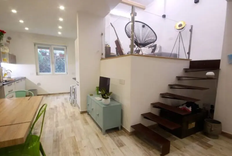 Puerta de entrada de vivienda moderna decorada con estilo minimalista y muebles de colores suaves en un ambiente amplio y luminoso.