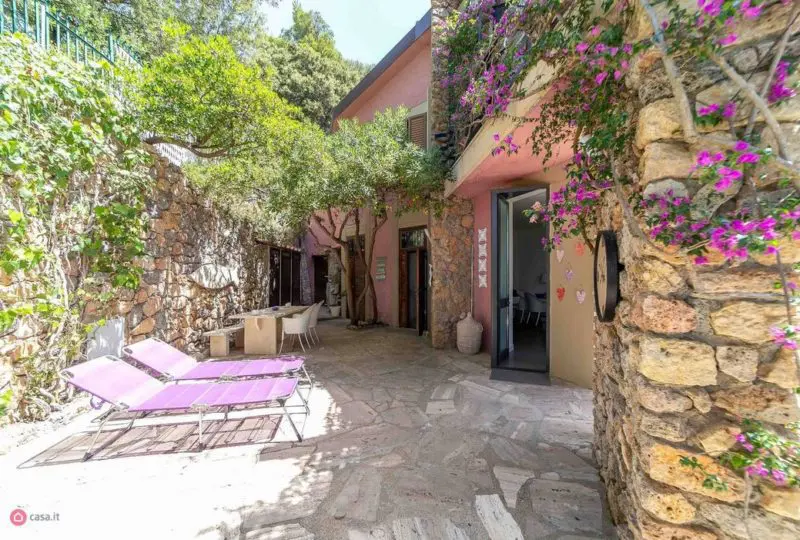 Hermoso patio exterior en propiedad de agencia inmobiliaria Horus con zona de descanso, vegetación y decoración acogedora, ideal para vivir o invertir en la Costa Brava.