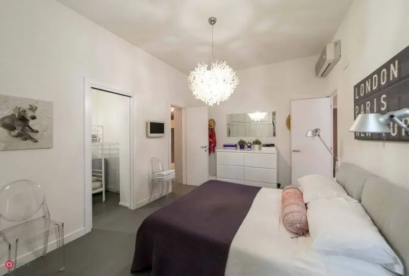 Lámpara de diseño en habitación moderna de la agencia inmobiliaria Horus Real Estate.