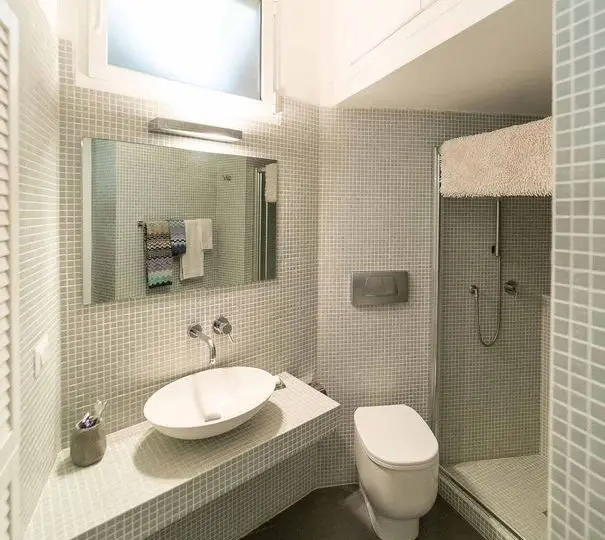 Moderno baño en casa de diseño minimalista con accesorios de lujo y azulejos de mosaico para un estilo contemporáneo en inmobiliaria Horus.