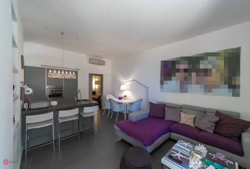Amplia sala de estar y cocina moderna en apartamento en alquiler, con mobiliario elegante y decoración minimalista, ideal para comprar o alquilar con la asesoría de Horus Inmobiliaria.