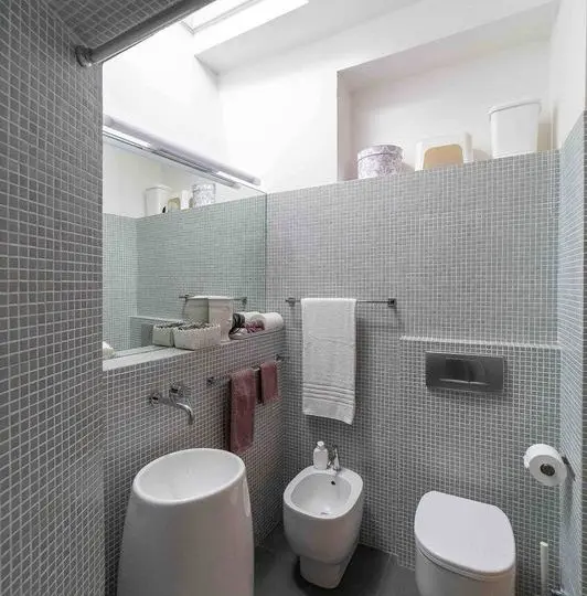Contenedor de lavabo y váter en un baño moderno con azulejos grises y accesorios elegantes, ideal para viviendas o propiedades en venta o alquiler.