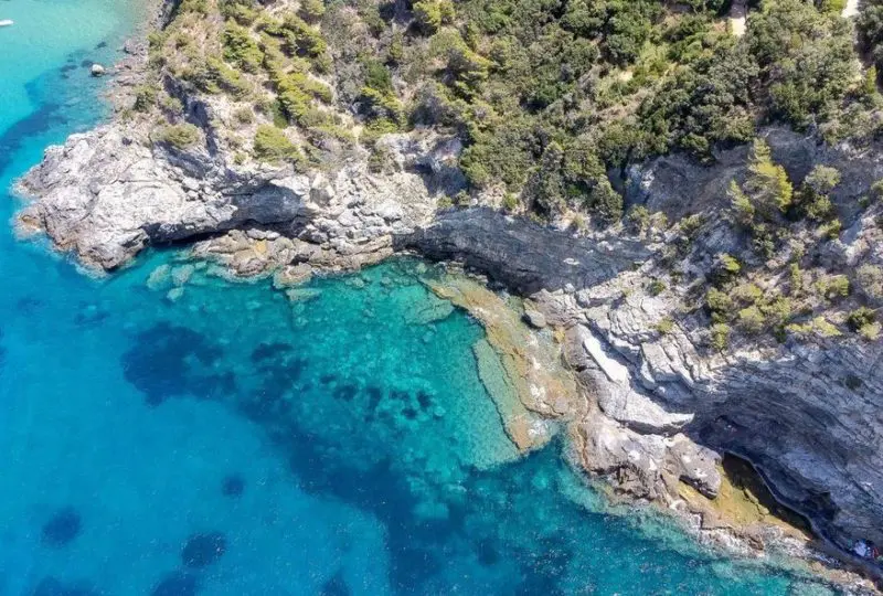 Carretera costera con vistas al mar Mediterráneo y formaciones rocosas, ideal para inversiones inmobiliarias exclusivas en zonas privilegiadas de playa en Mallorca.