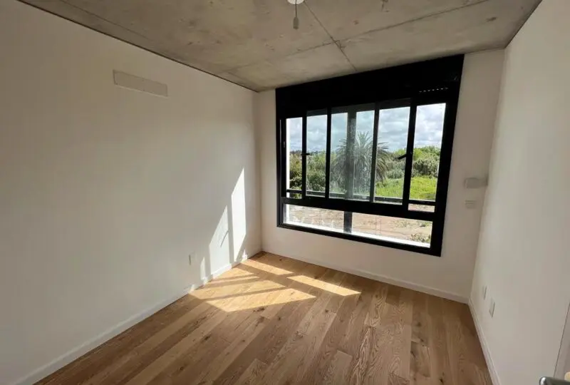 Luz natural y modernas ventanas en habitación moderna en construcción en inmobiliaria Horus.
