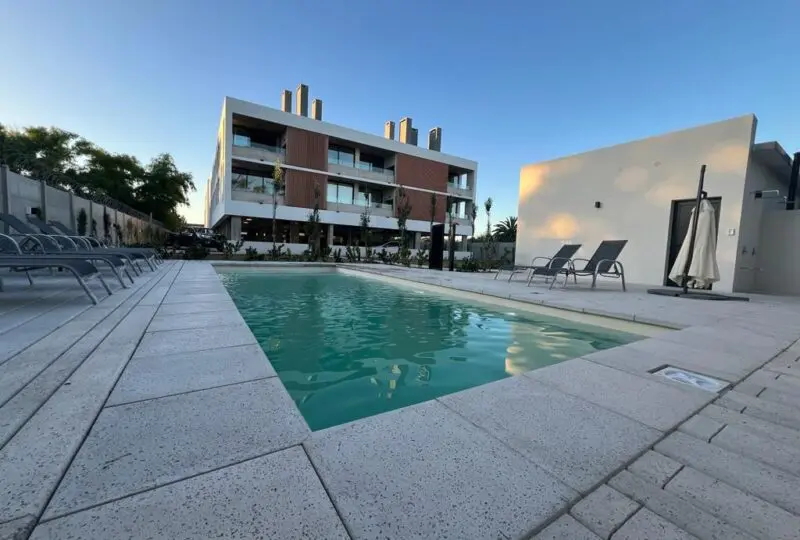Piscina moderna en complejo residencial de lujo con áreas de descanso y jardines, ideal para familias. Propiedades en venta y alquiler en la mejor zona de la ciudad.