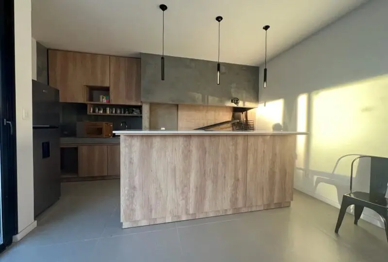Moderno diseño de cocina en apartamento nuevo, con mobiliario de madera, electrodomésticos y ambiente luminoso ideal para residir o invertir en bienes raíces en España.