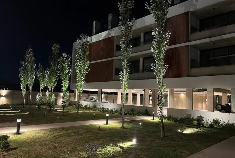 Moderno edificio residencial con iluminación exterior en zona urbanizada, ideal para inversión y compra de propiedades de lujo.