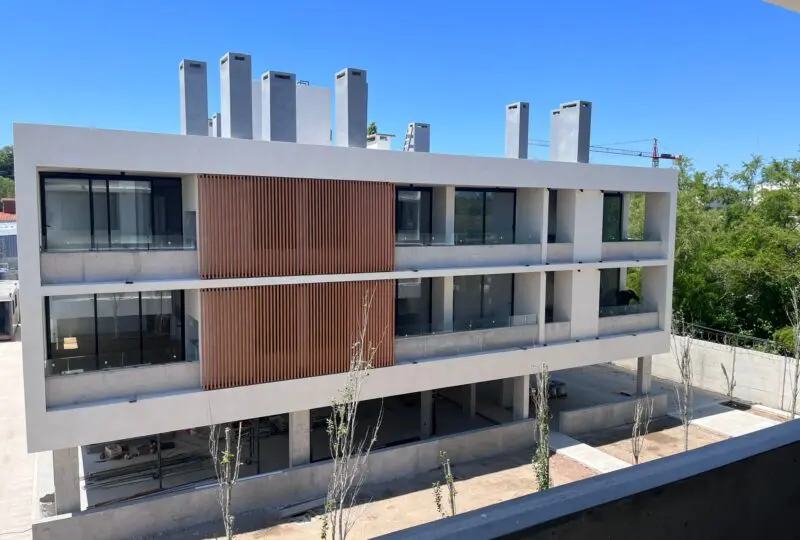 Moderno edificio residencial en construcción con amplias ventanas y balcones, ideal para inversión inmobiliaria en zonas en crecimiento.