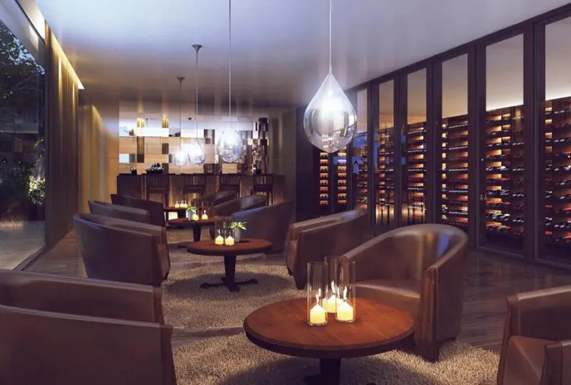 Moderno salón de vinos con paredes de botellas y muebles de lujo en Horus Real Estate Agency, espacio elegante para clientes y coleccionistas.
