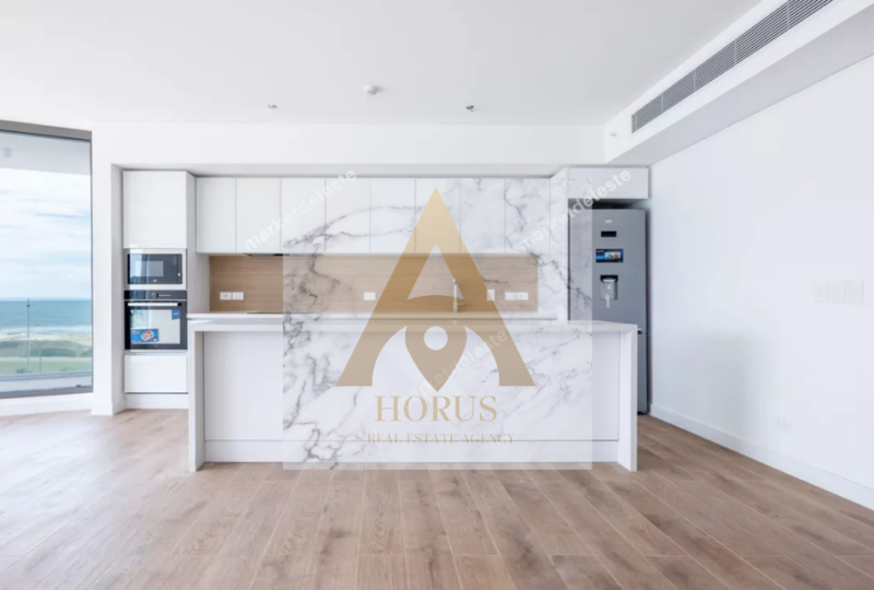 Moderno salón con cocina de diseño minimalista y vistas panorámicas al mar en propiedad en Canarias. Propiedad en venta con excelentes conexiones y acabados de lujo.