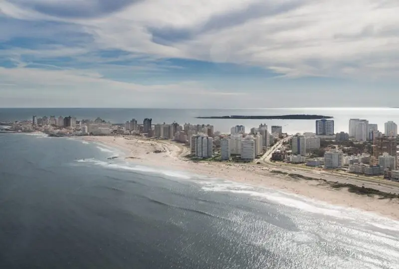 Playa y skyline de la ciudad costera vista desde el aire, propiedades frente al mar, agencia inmobiliaria Horus Real Estate Agency, inversión en bienes raíces en la playa, propiedades en ubicación privilegiada en la costa valenciana.
