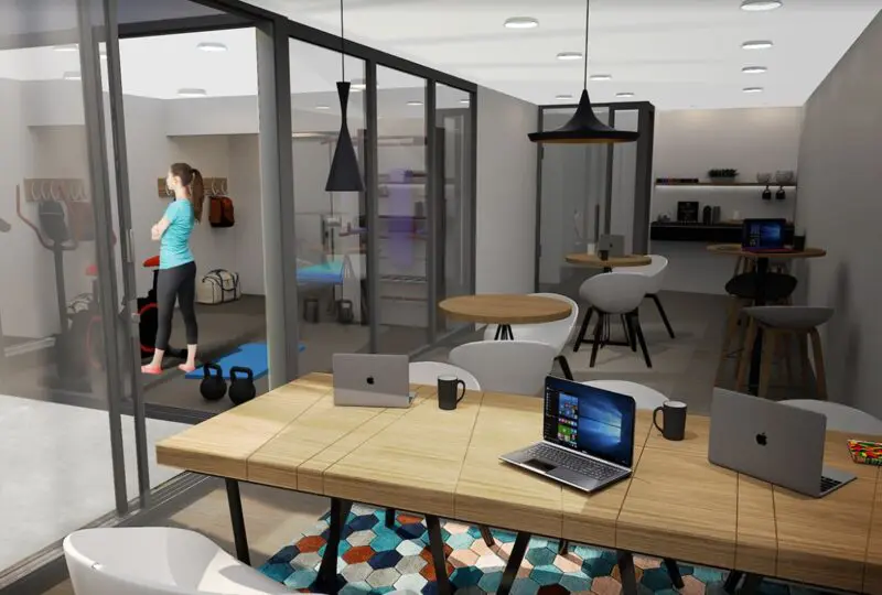 Oficina moderna de agencia inmobiliaria Horus con área de entrenamiento y espacio de trabajo equipado con laptops y mobiliario contemporáneo.