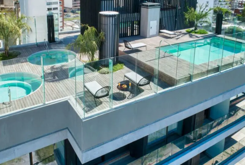 Esquina de terraza en ático con piscina y jacuzzi en edificio moderno en Madrid, espacios exteriores diseñados para el bienestar y el ocio en propiedades premium de Horus Bienes Raíces.