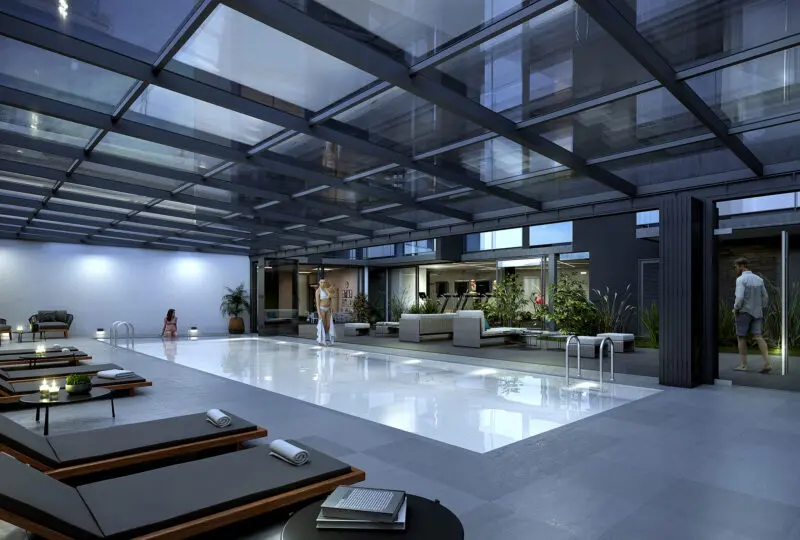 Relaxe en la piscina cubierta del moderno complejo de Horus Inmobiliaria, con áreas de descanso y exuberantes plantas, en un entorno elegante y sofisticado para tu bienestar.