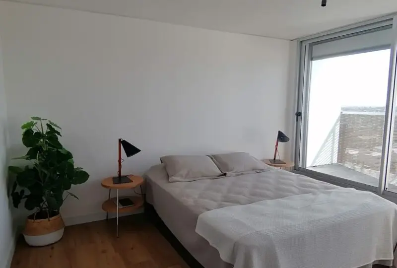 Amplio dormitorio en inmueble de lujo con balcón y vistas a la ciudad, completamente amueblado, ideal para vivir o invertir, en zona residencial exclusiva.