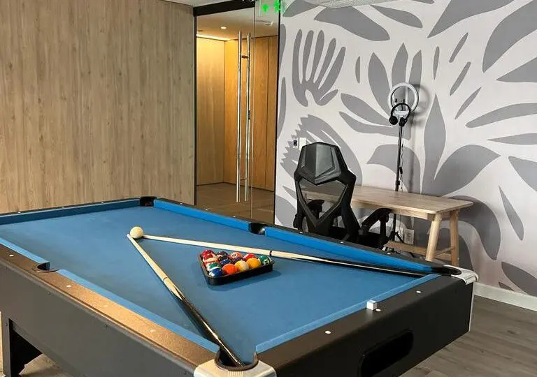 Billar en sala moderna, ambiente cómodo y profesional, ideal para reuniones y ocio en prestigiosa agencia inmobiliaria Horus Real Estate.