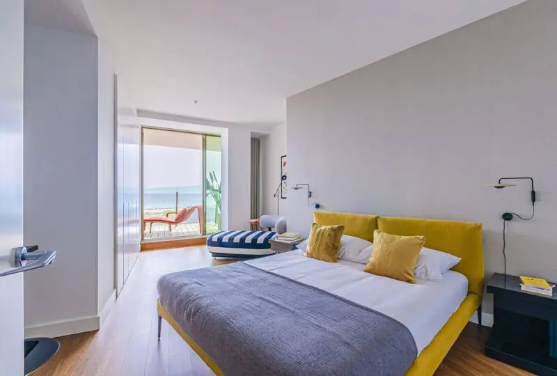 Amplio dormitorio con vistas al mar, decoración moderna y elegante, mobiliario de diseño, perfecta para propiedades en la playa en la web de Horus Real Estate Agency.