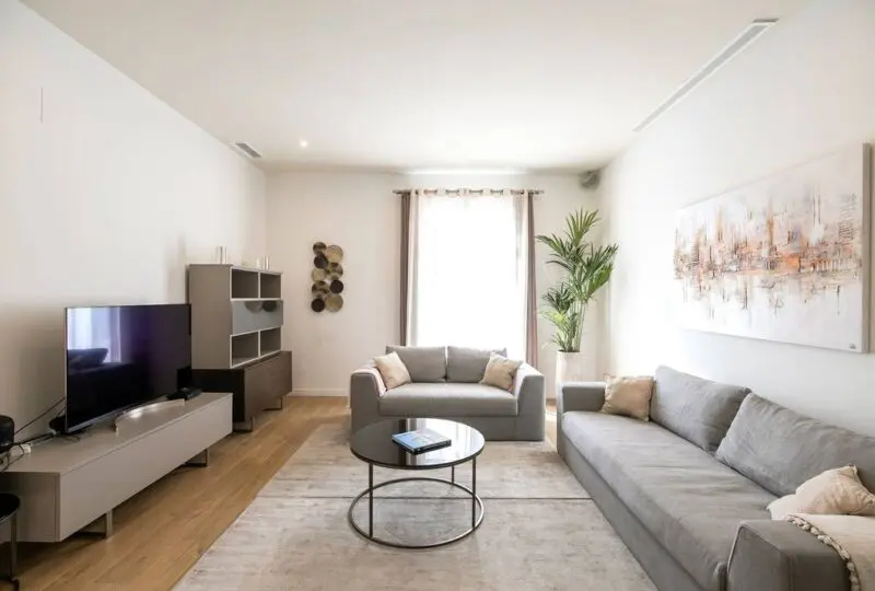 Amplia sala de estar moderna con mobiliario elegante, diseñada por Horus Inmobiliaria para residencias de lujo. Espacio luminoso con decoración contemporánea, perfecta para familias y profesionales en búsqueda de su hogar ideal.