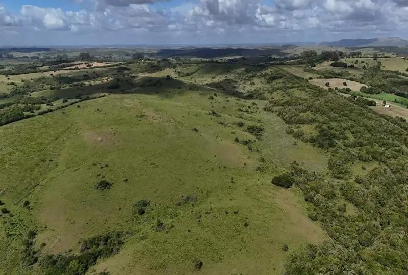 Amplia vista de terrenos rurales y agrícolas en venta en un entorno natural con colinas y vegetación en las que destaca la belleza del paisaje campestre.