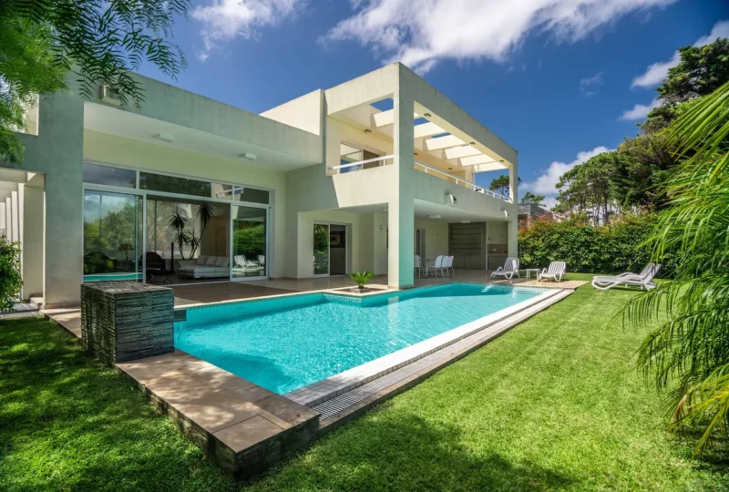 Amplia casa moderna con piscina, jardín y espacios de lujo en una exclusiva zona residencial, ideal para comprar o invertir en bienes raíces de alta calidad.