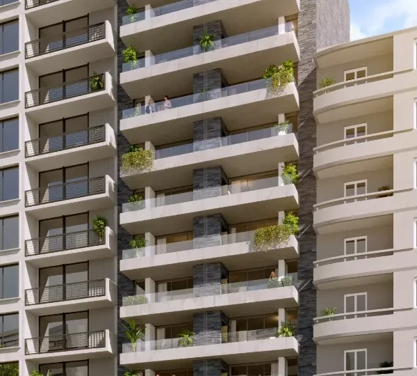 Moderno edificio de apartamentos en construcción en una avenida de la ciudad, con amplias terrazas y áreas verdes en los balcones, ideal para inversión inmobiliaria en zonas urbanas de alta demanda.