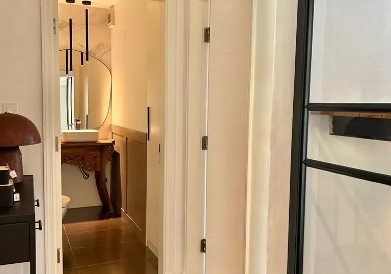 Puerta de entrada a un moderno baño en un apartamento en alquiler en Horus Real Estate Agency. Diseño elegante y funcional con acabados contemporáneos y excelente iluminación natural.