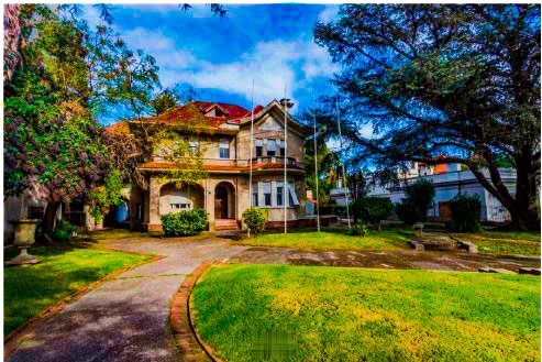 Casa señorial rodeada de jardines verdes en una zona residencial exclusiva en el centro de la ciudad, ideal para inversión y vida familiar.